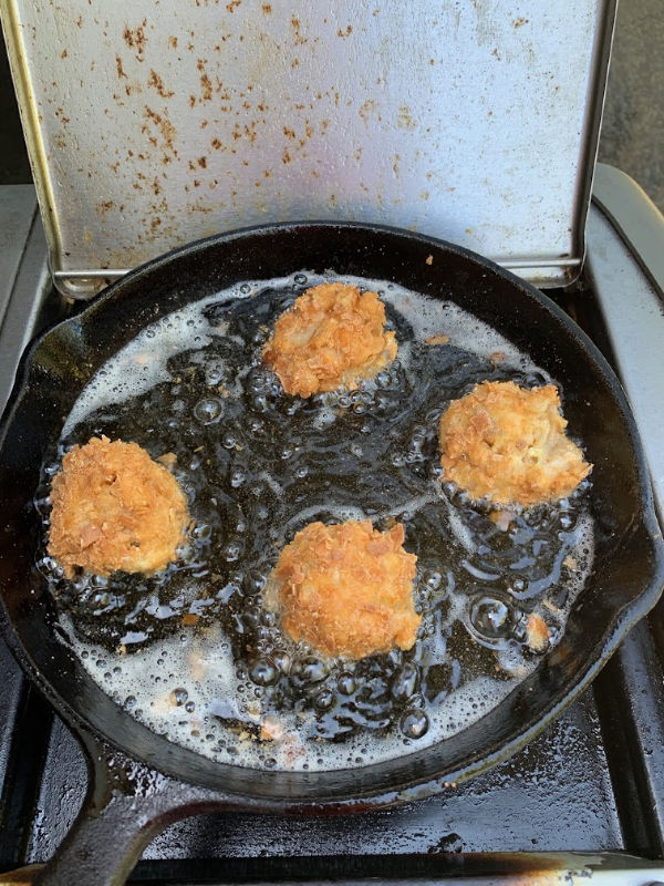 Mac and cheese balls frying in hot oil.