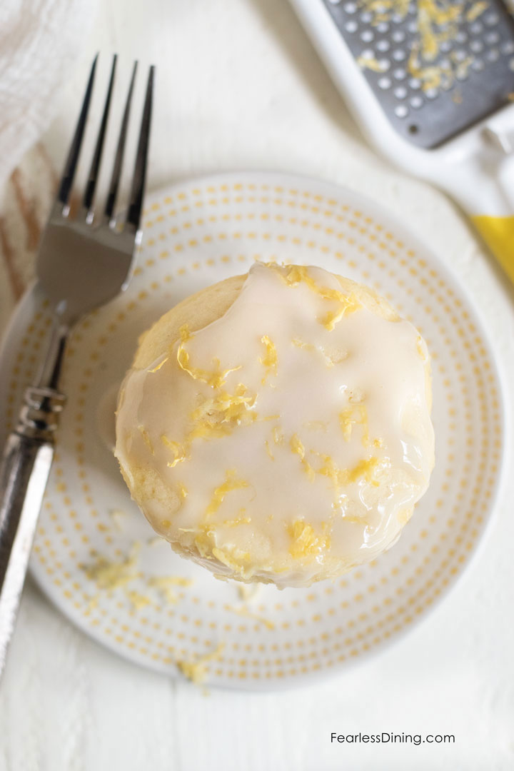 The top view of the lemon mug cake with icing and lemon zest.