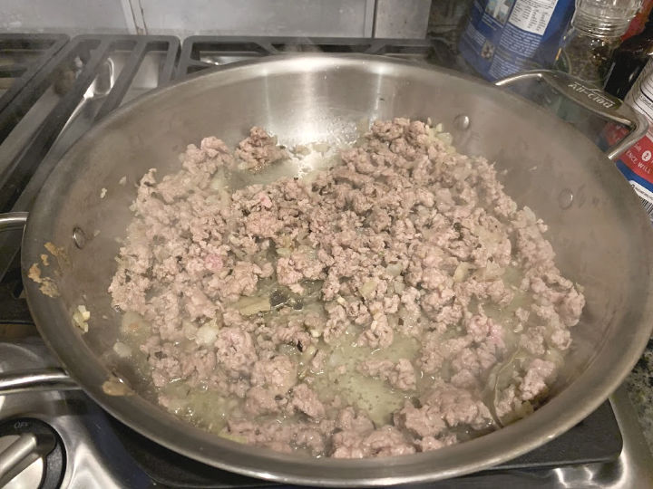 cooking ground pork with onion and seasonings in a large pan