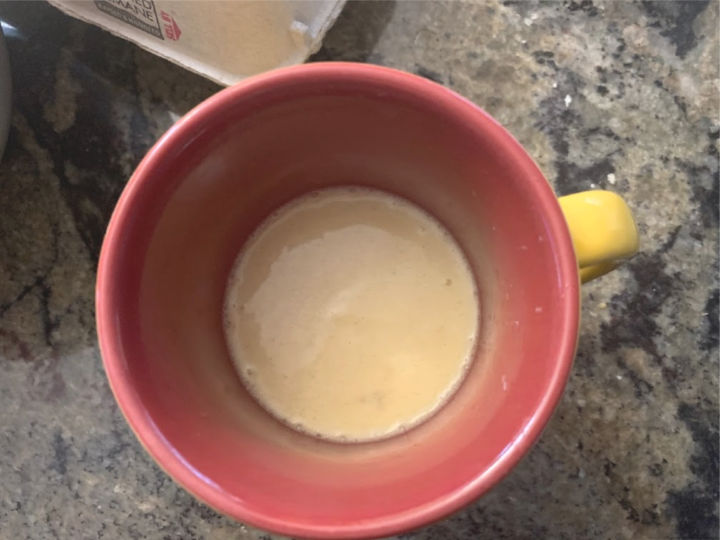 Top view of a microwave cake batter in a red and yellow mug.