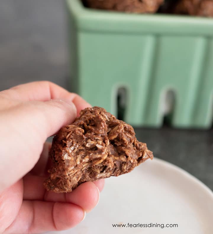 Holding a cookie and the cookie has a bite taken out.