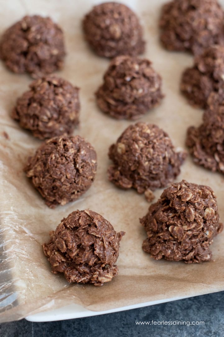 A wax paper lined tray full of no bake chocolate oat cookies.