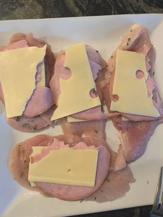 Raw chicken with Swiss cheese on top.