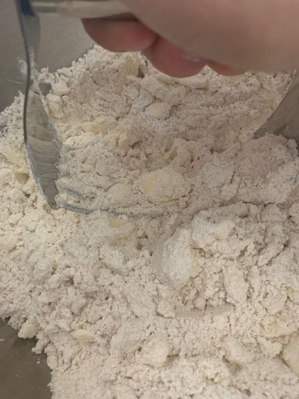 Using a pastry blender to cut the cold butter into the flour