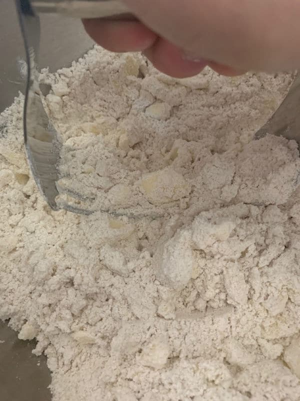 Cutting butter into flour with a pastry cutter.