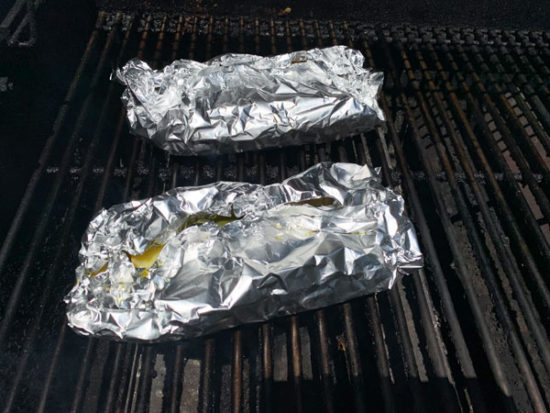 Foil packets with the fish and veggies on the grill.