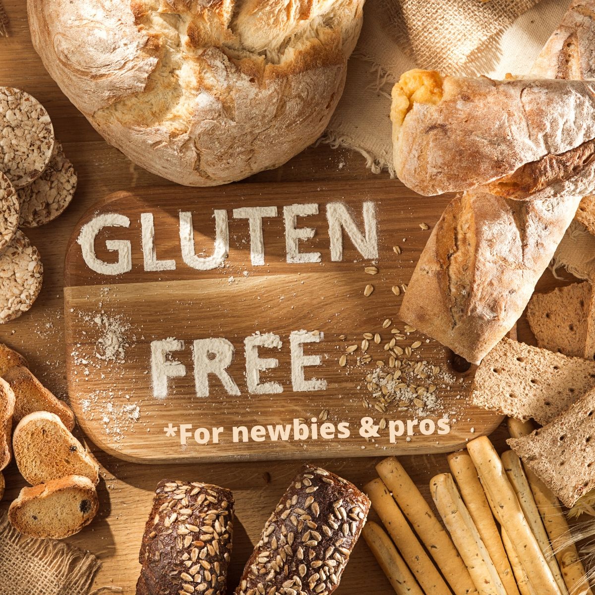 A kitchen counter filled with gluten free bread loaves, crackers, and pasta. The words gluten free for newbies and pros is written on the cutting board.