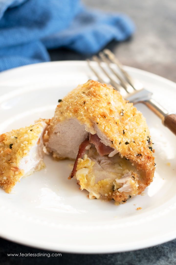A piece of chicken cordon bleu cut open so you can see the ham and melted cheese.