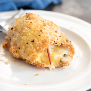 A serving of chicken cordon bleu on a white plate.