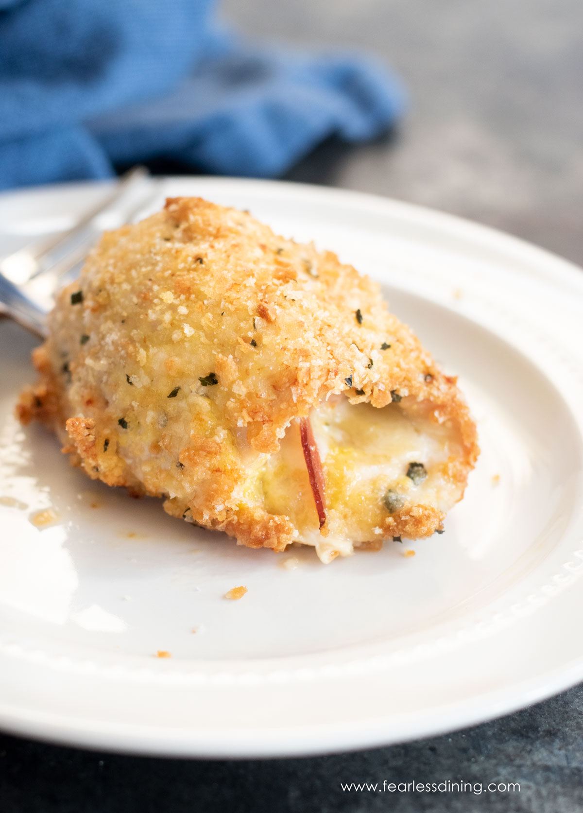 A serving of chicken cordon bleu on a white plate.