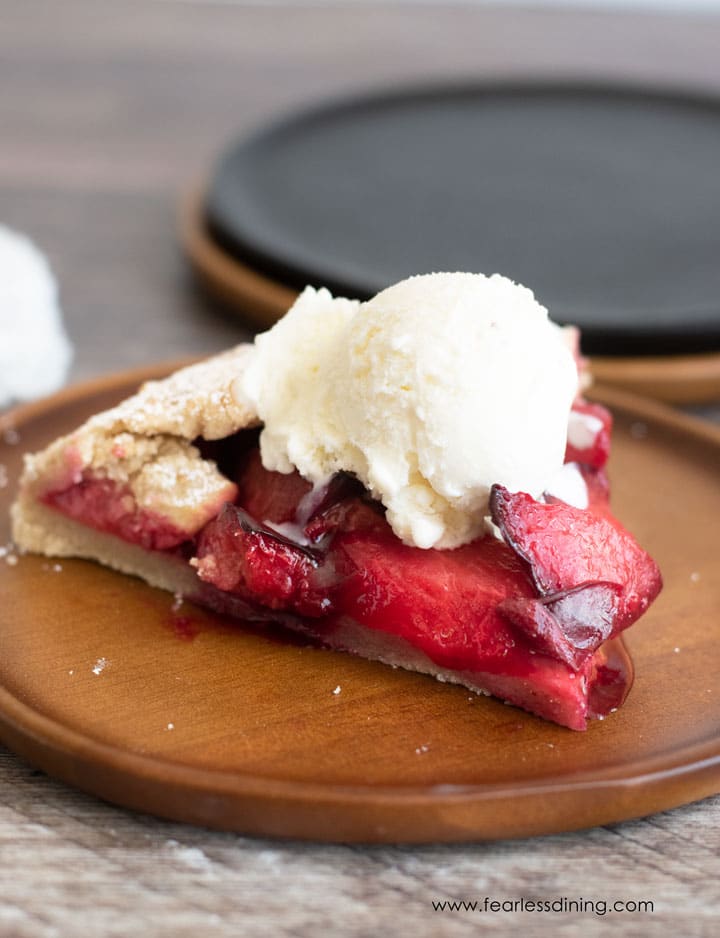 A slice of plum galette topped with vanilla ice cream.