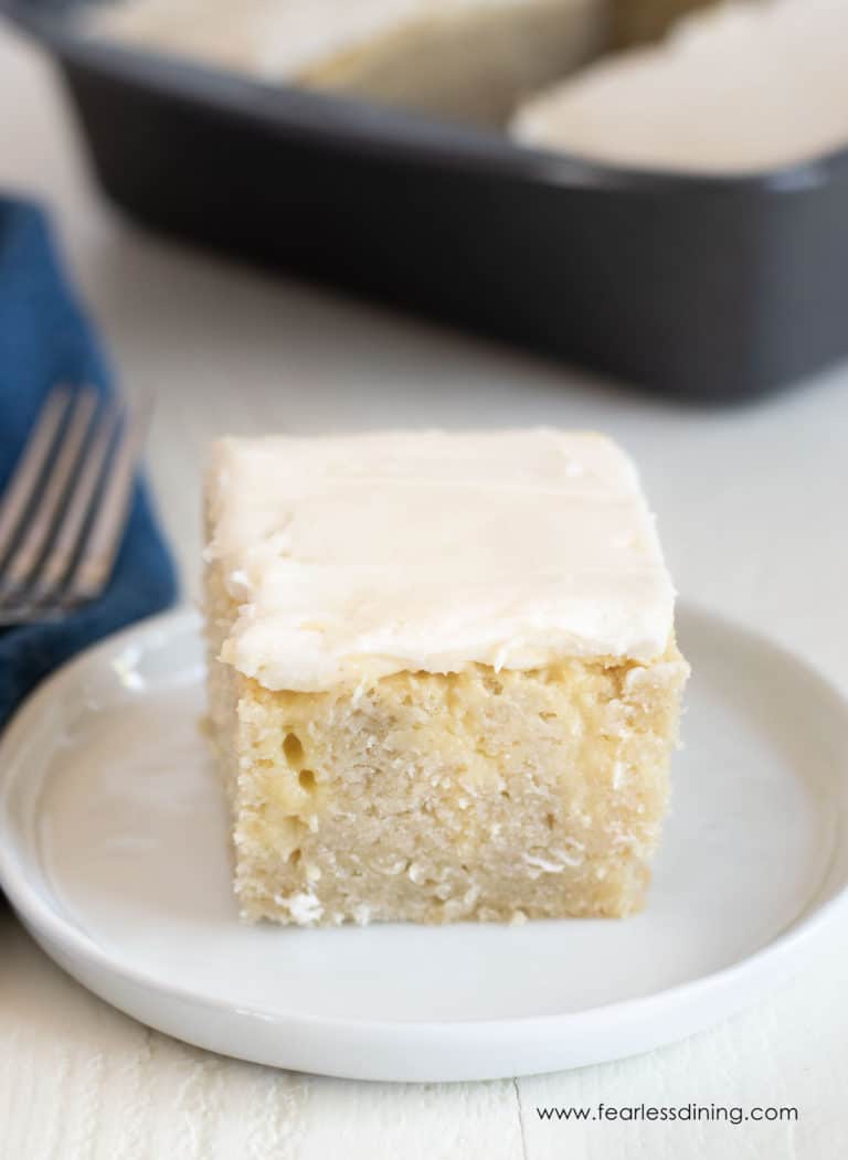 A slice of gluten free poke cake on a small white plate.