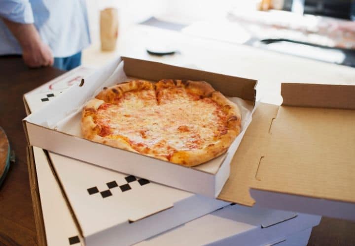 pizza in a take out box on a counter