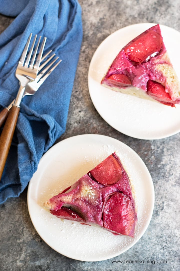 Two slices of plum upside down cake on plates.