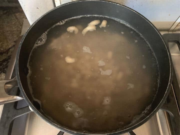 A pot filled with boiling macaroni.