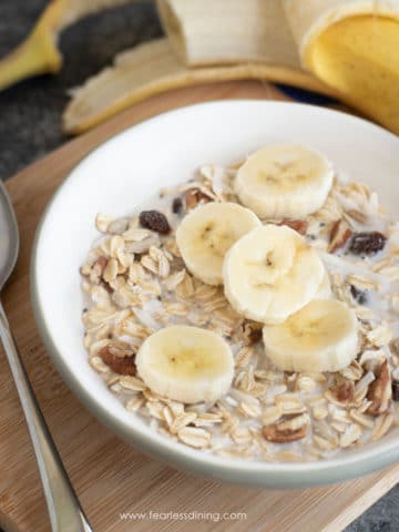 a close up of a bowl of muesli with sliced bananas