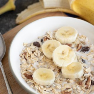 a bowl of muesli topped with sliced bananas