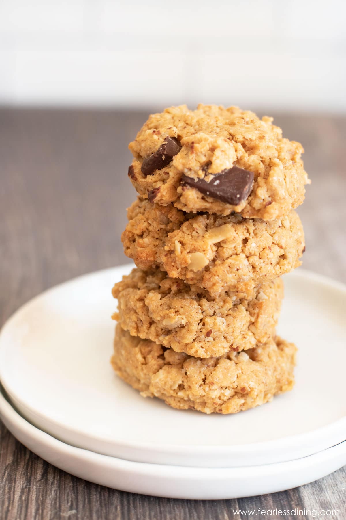a stack of four gluten free peanut butter oat cookies on a white plate