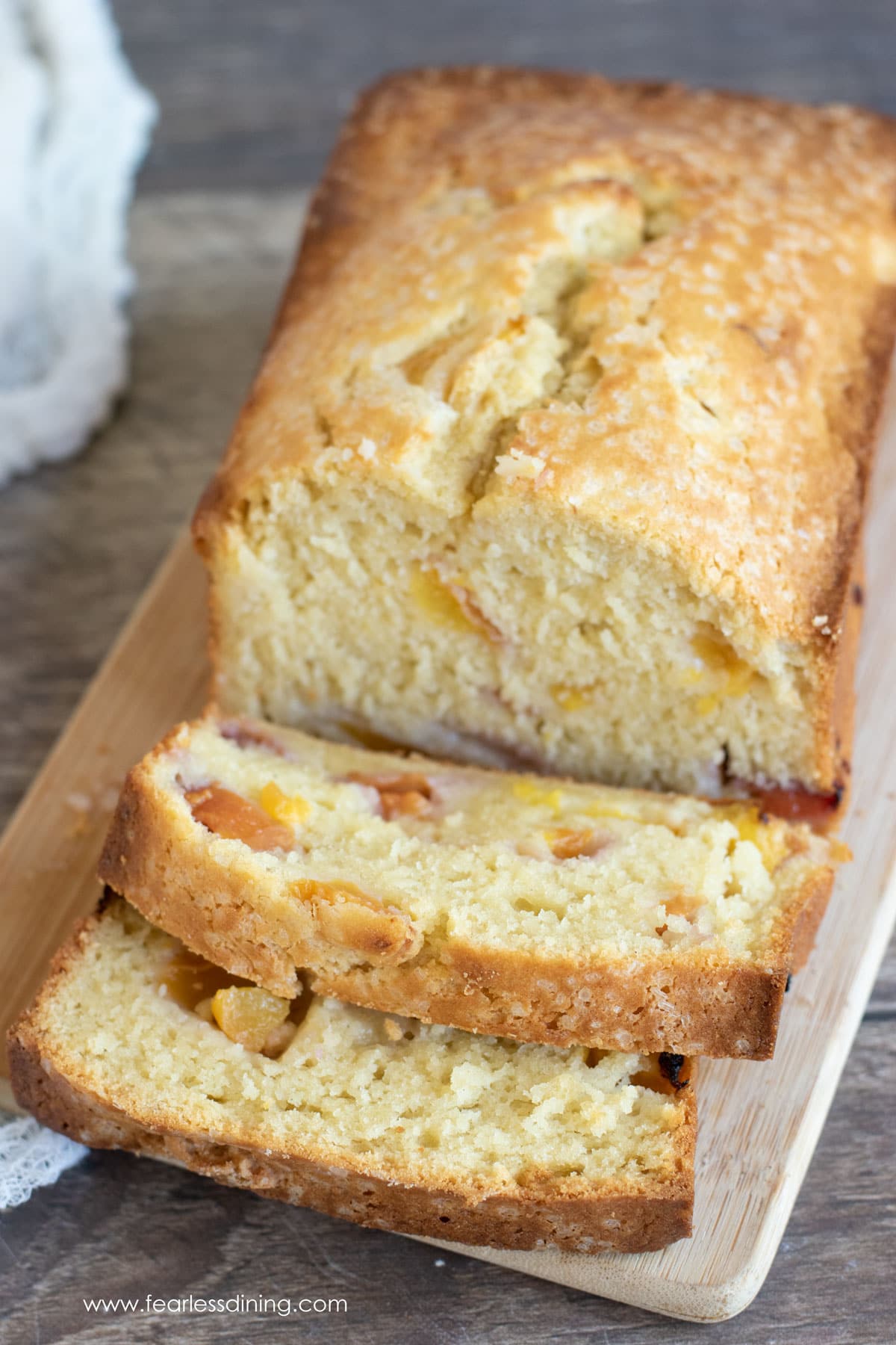 A sliced peach cake on a cutting board.