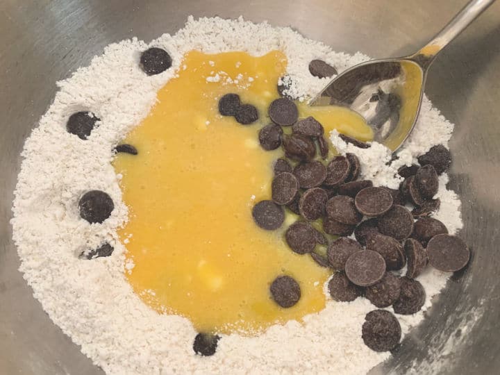 The wet and dry ingredients with chocolate chips in a bowl ready to be mixed.