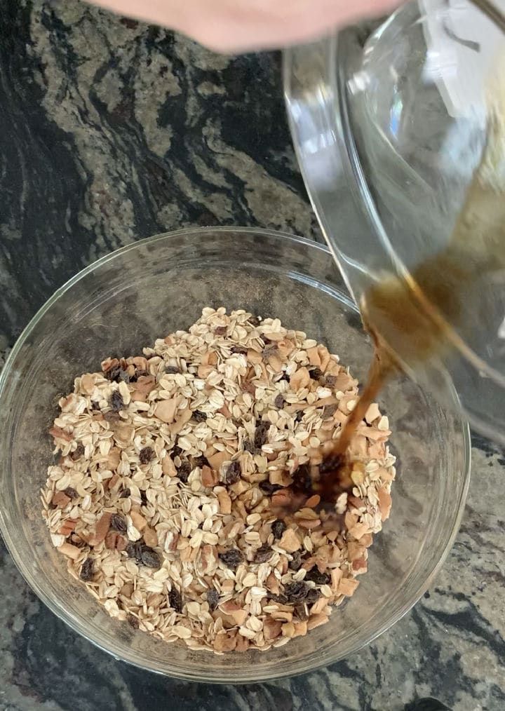 Pouring the maple syrup over the oat mixture.