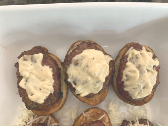 lamb burgers topped with dijon sauce on a plate