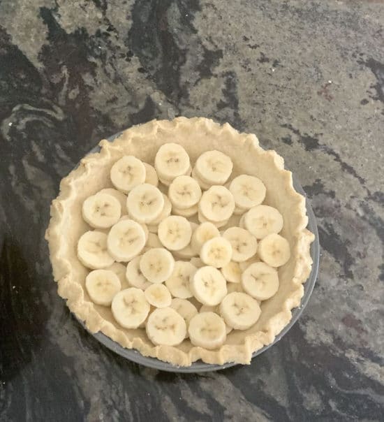 The banana slices in a baked pie crust.