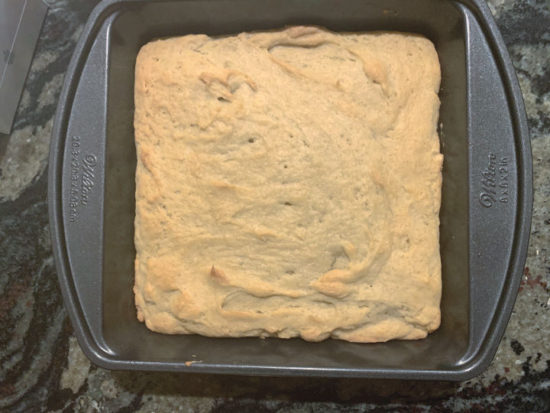 A baked cake in the square 8x8 pan.