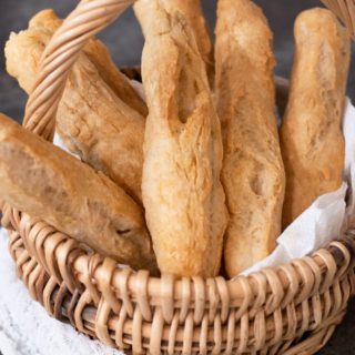 A basket full of gluten free breadsticks on a table