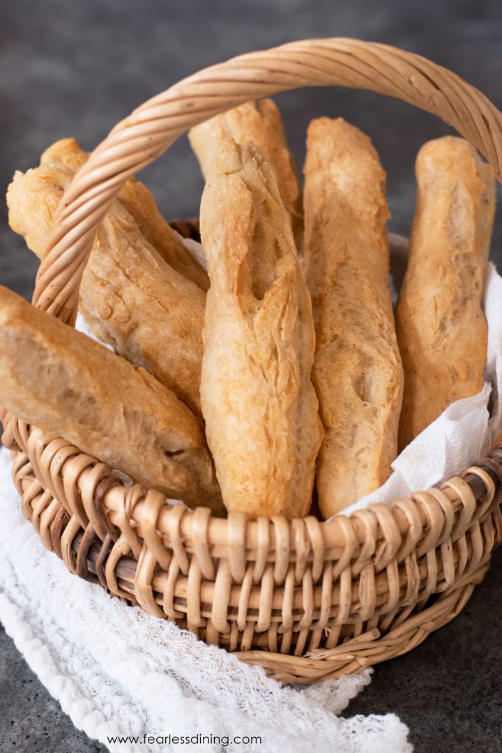 A basket full of gluten free breadsticks on a table