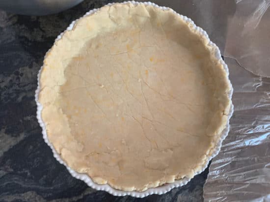 A large pie dish with the bottom crust pressed into it.