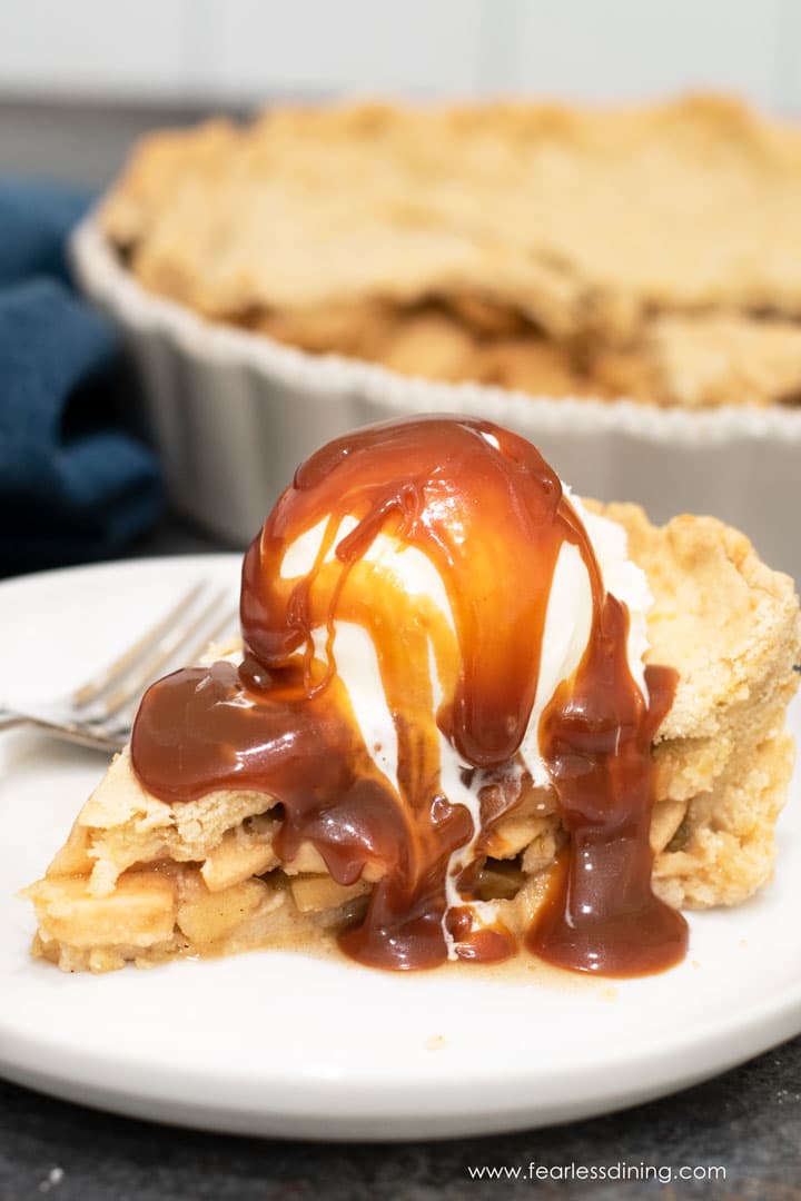 A slice of green chile apple pie with a scoop of vanilla ice cream and caramel sauce