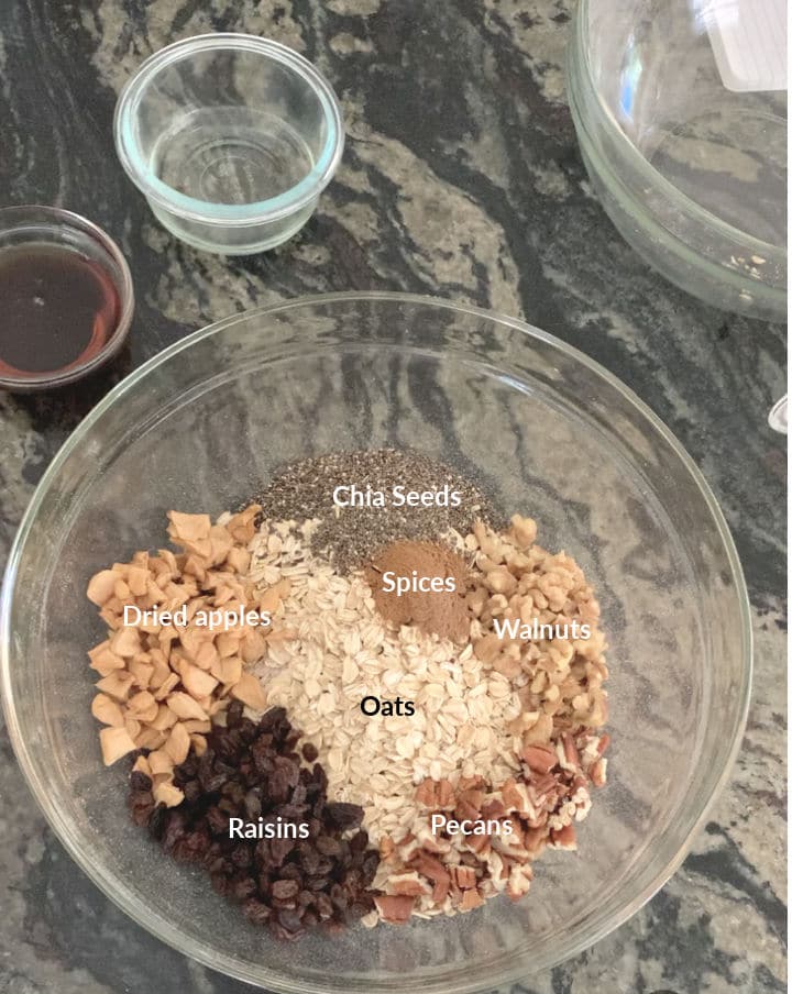 A large bowl filled with the ingredients of the granola. Each ingredient is listed.