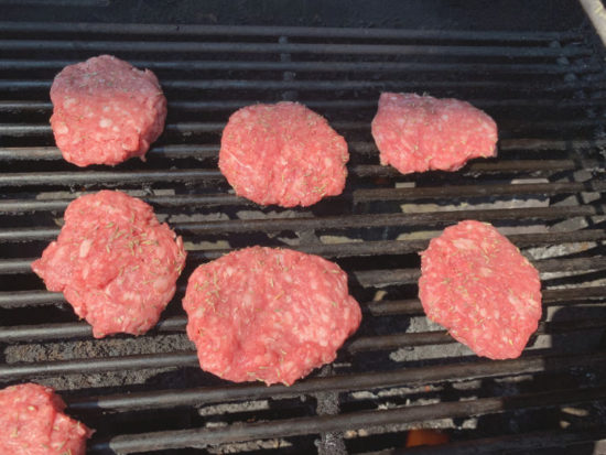 Burgers cooking on the grill.