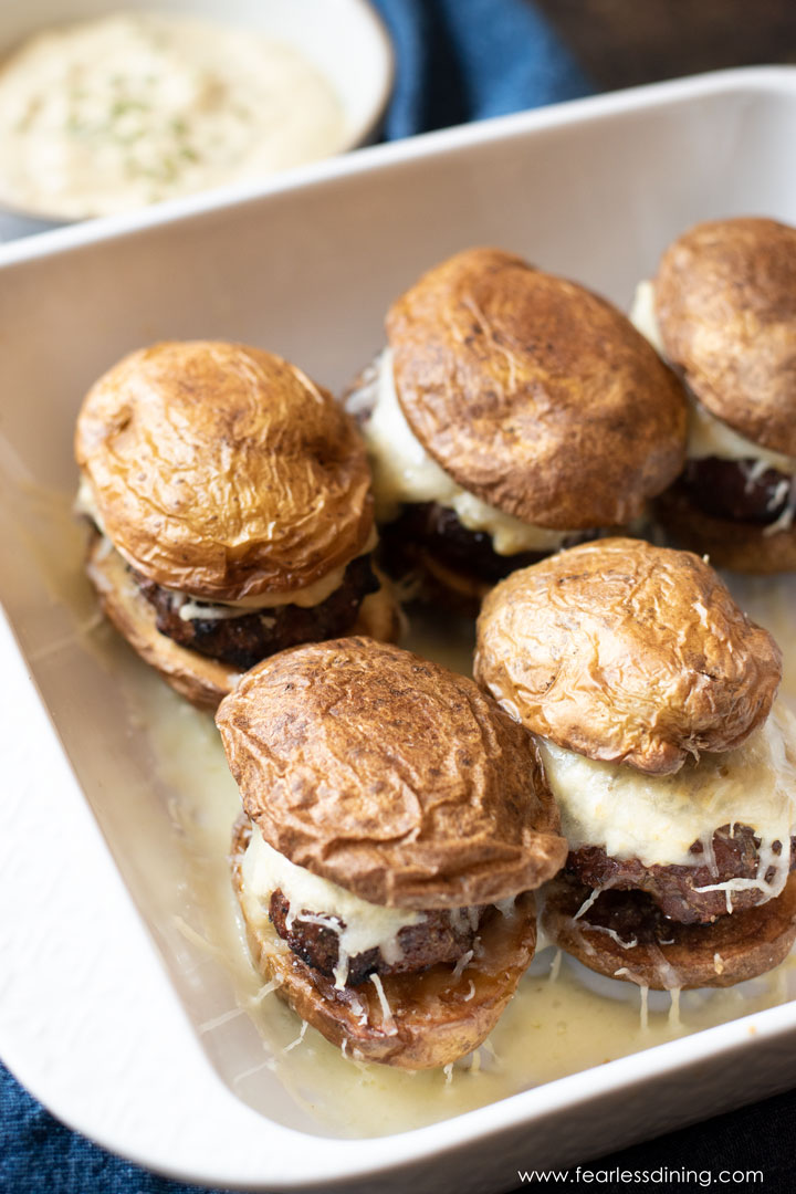 A white ceramic baking dish filled with lamb sliders.