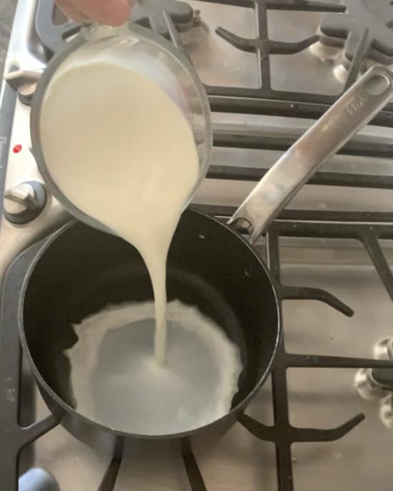 pouring milk into a sauce pan