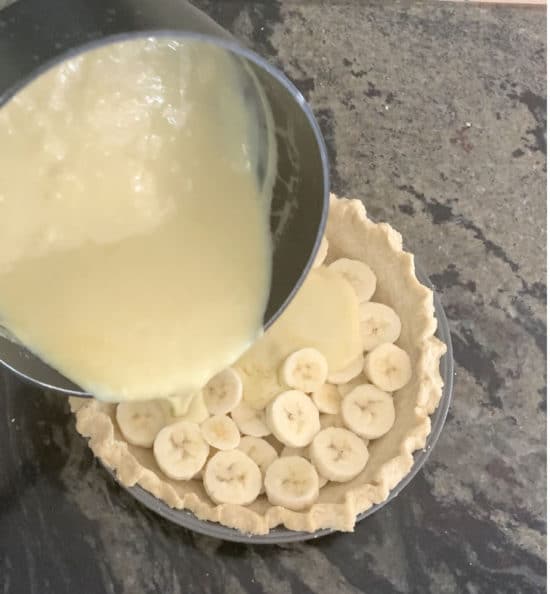 Pouring the vanilla pudding over the banana slices.