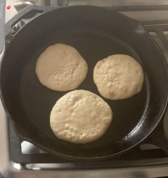 Pancakes bubbling in a skillet.