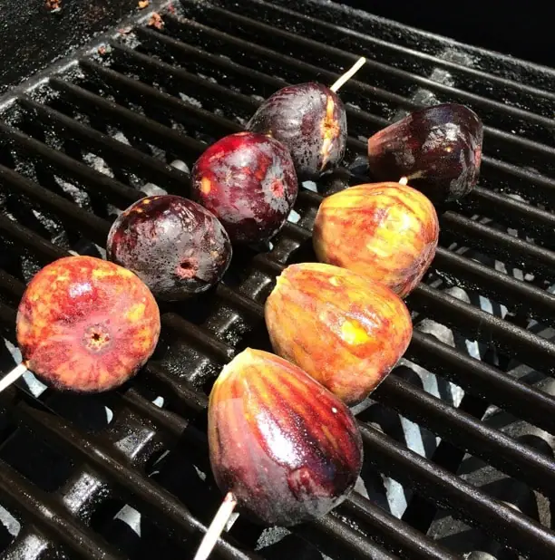 figs on skewers cooking on a grill