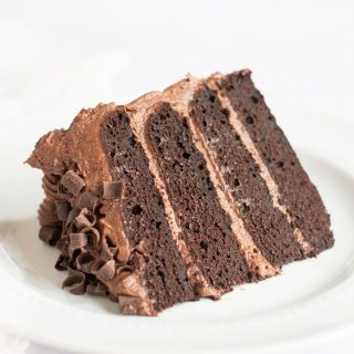 A gluten free chocolate cake slice on a white plate.
