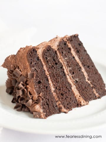 A gluten free chocolate cake slice on a white plate.