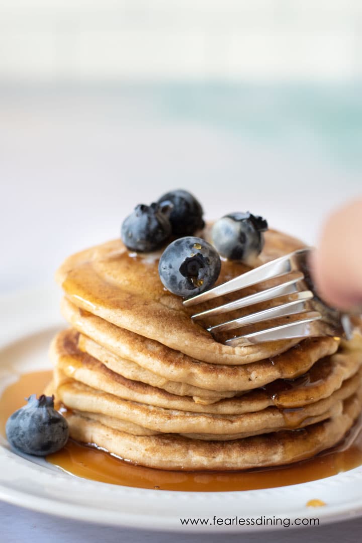 A fork cutting through a stack of pancakes.