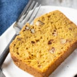 A close up of a slice of pumpkin bread on a plate.