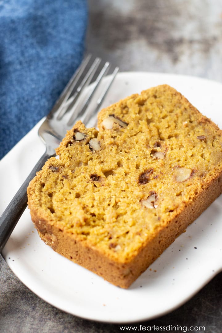 A close up of a slice of pumpkin bread on a plate.
