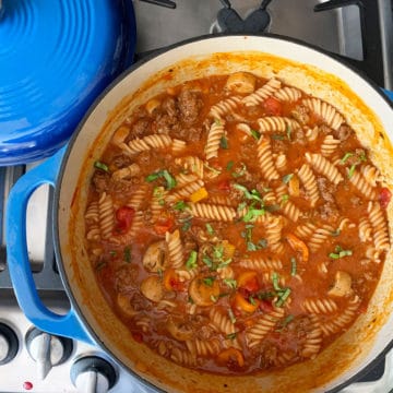 a blue cast iron pot full of one pot tomato basil pasta