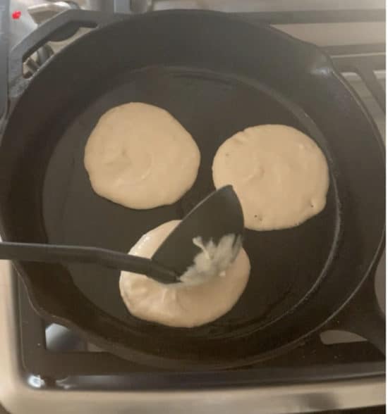 Pouring pancake batter into a pan.