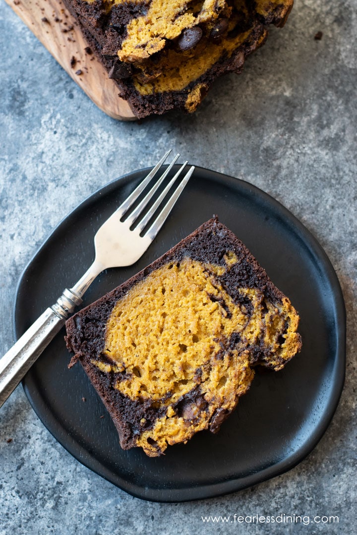 A slice of chocolate pumpkin cake on a dark wooden plate.
