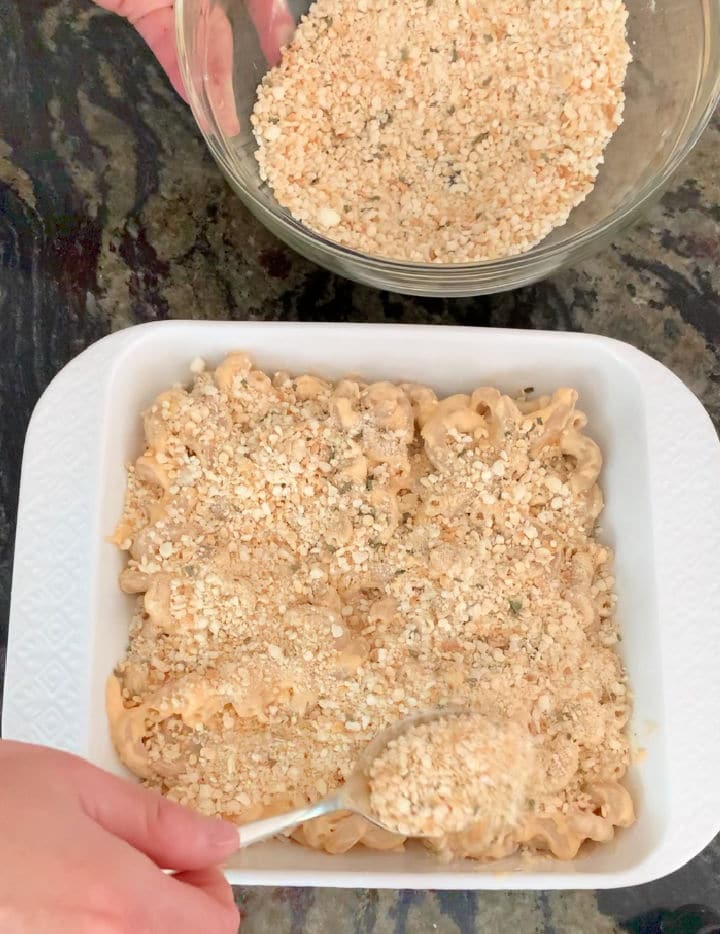 spreading the panko topping over the mac and cheese.