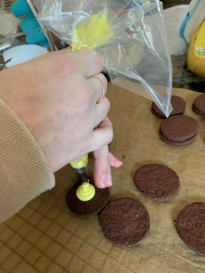 Using a piping bag to frost a cookie.