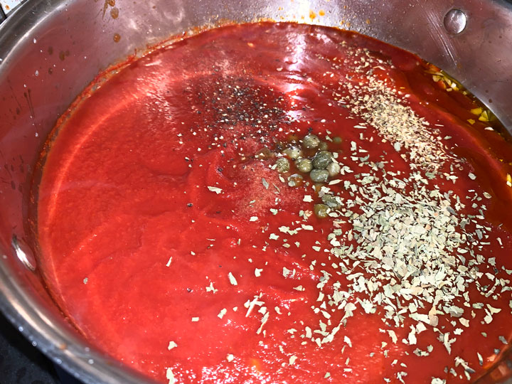 All of the marinara ingredients in a pot.